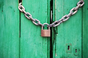 Brass colored metal padlock with chain