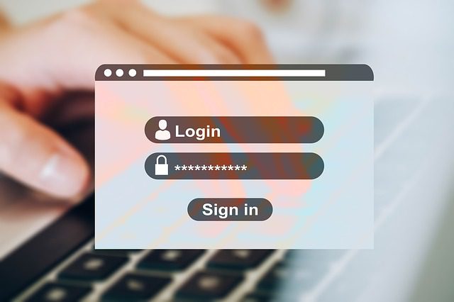 An image of a login page for website with a person typing on a keyboard in the background.