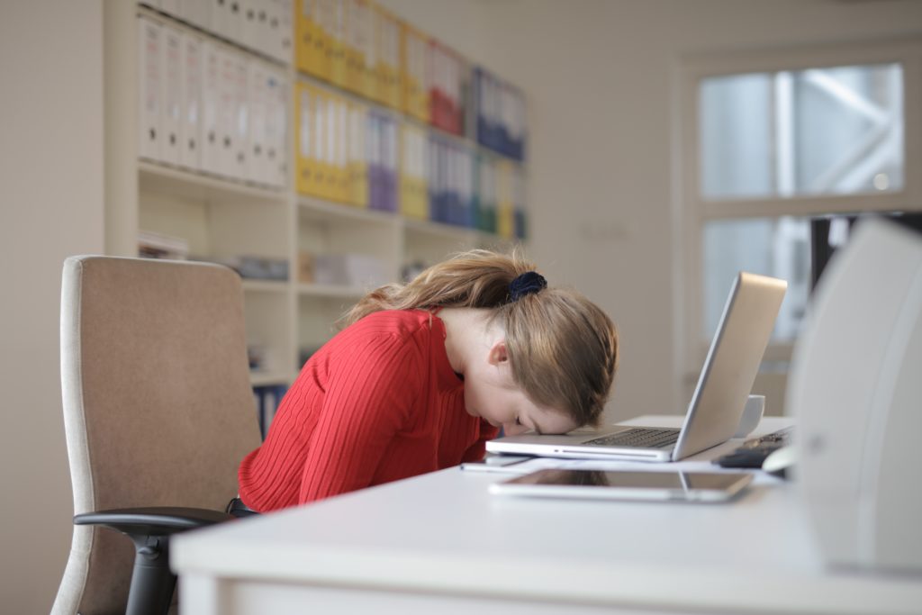 Woman sitting on chair while leaning on laptop