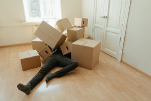 Person in black pants lying on brown cardboard boxes