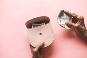 senior women hand saving cash in wallet
