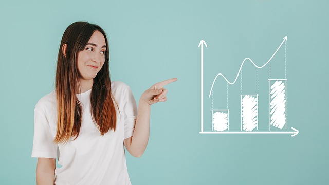A woman pointing at a chart showing business improvement, symbolizing how data analytics can help your business.