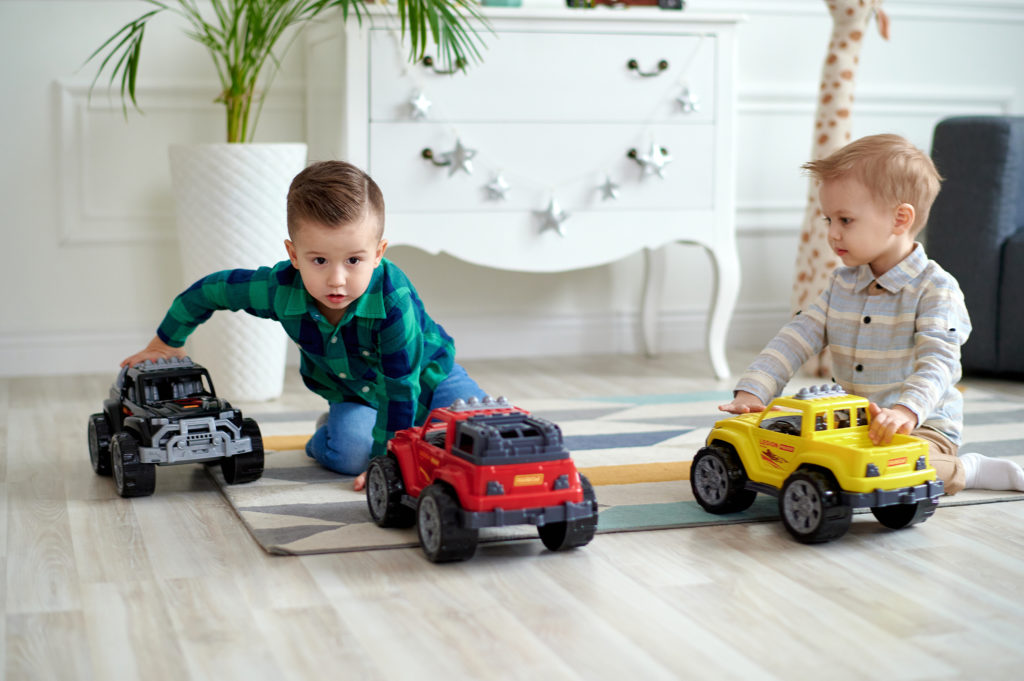 A boys playing toy cars together