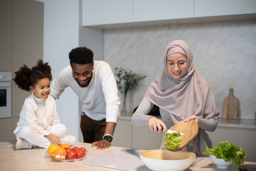 Positive multiracial family cooking together in kitchen