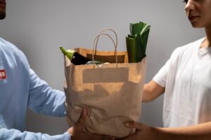 People holding a brown paper bag